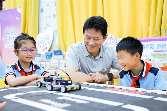 1758680788959095628.jpg 王强书记与湖北随州随县淮河镇小学的学生在汽车课上互动。.jpg